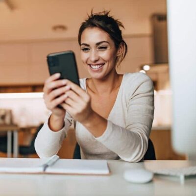 woman in kitchen looking at invisalign tips on phone