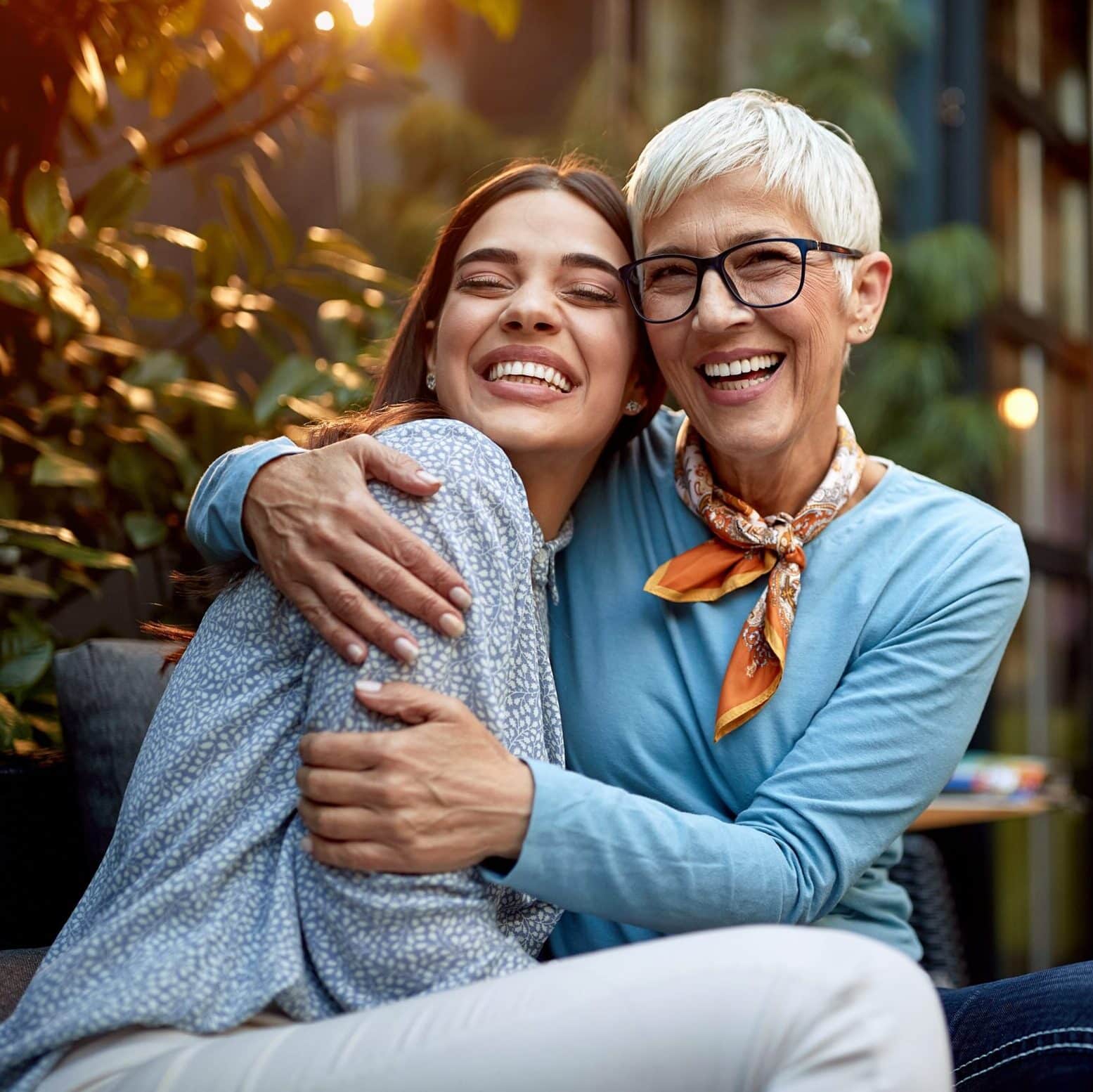 adult mother and daughter with straight teeth hugging outside