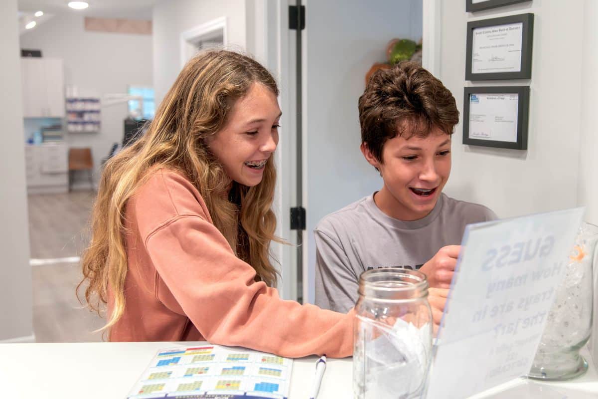Grosso-orthodontics-first-visit Boy and girl smiling at the front desk of grosso orthodontics in south carolina