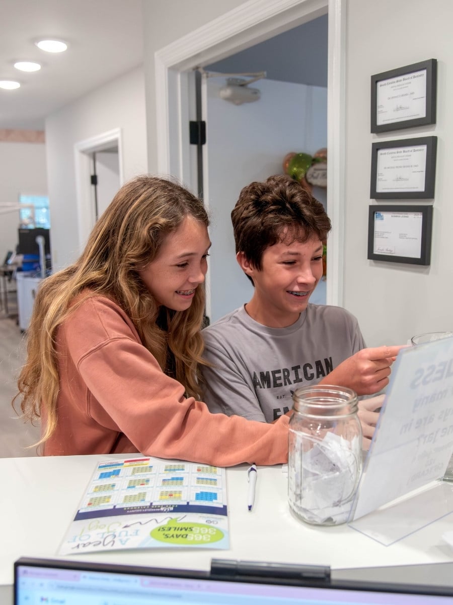 Grosso-early-orthodontics Young braces patients reviewing orthodontic information at grosso orthodontics in summerville, moncks corner, and georgetown, sc.